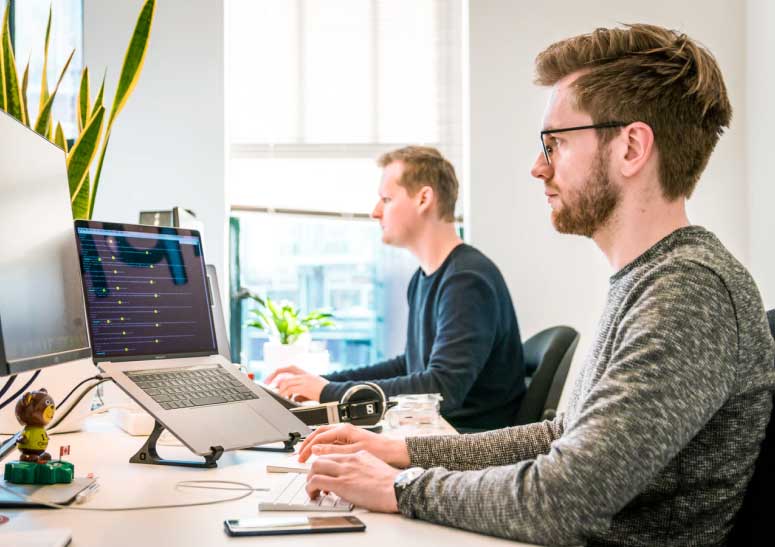 Men at work on a computer in 2M Consulting Grup SL offices